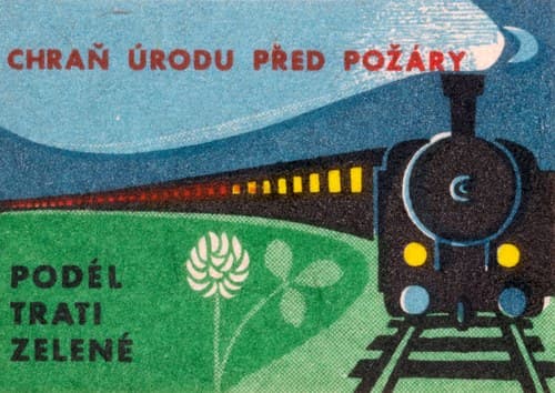 Černá parní lokomotiva jede přímo na diváka, za ní se táhne vlak se žlutě svítícími okny. Vlevo zelené pole s klasem a jetelem.